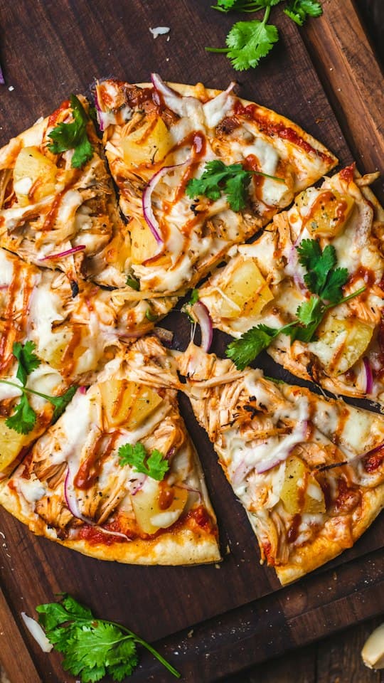 Pizza découpée en parts sur une planche en bois